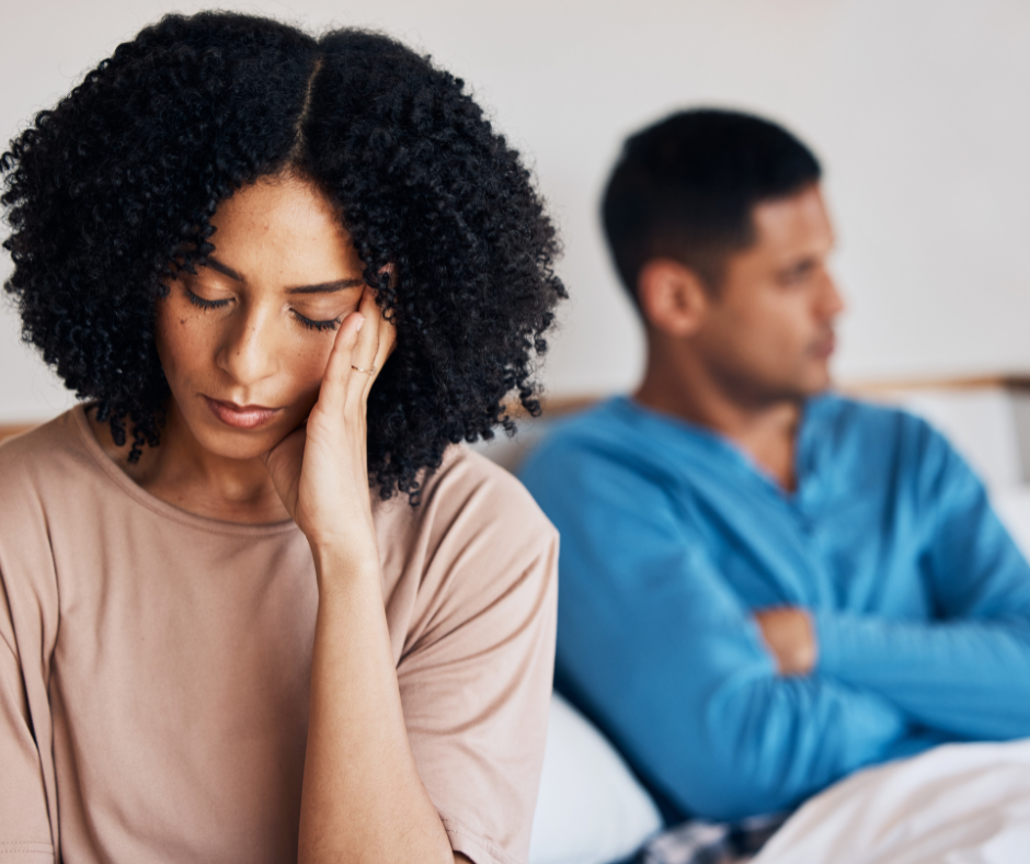 man and woman sitting on the bed with body language that indicates that they had a bad argument as a visual representation of understanding the causes of toxic relationships.